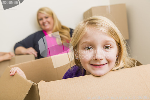 Image of Young Mother and Daughter Having Fun With Moving Boxes