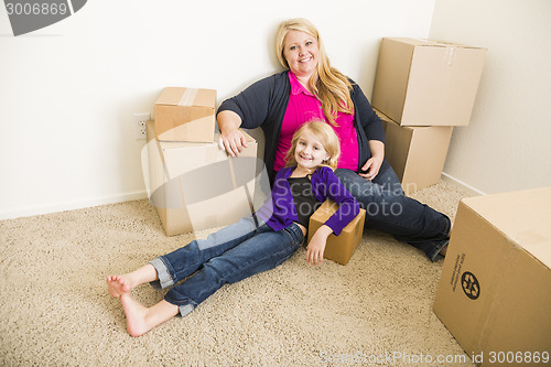 Image of Young Mother and Daughter In Empty Room With Moving Boxes