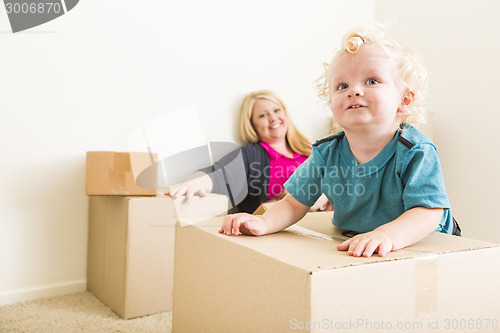 Image of Happy Mother and Son in Empty Room with Moving Boxes