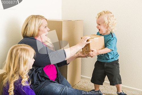 Image of Young Family In Empty Room Playing With Moving Boxes