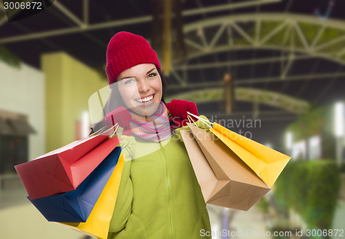 Image of Warmly Dressed Mixed Race Woman with Shopping Bags