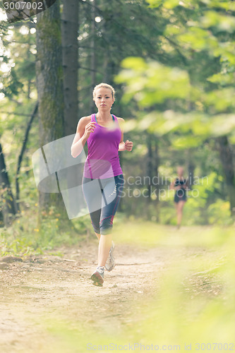 Image of Pretty young girl runner in the forest. 