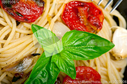 Image of spaghetti pasta with baked cherry tomatoes and basil 