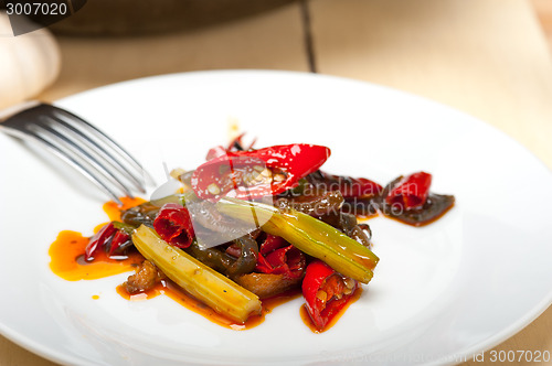 Image of fried chili pepper and vegetable on a wok pan