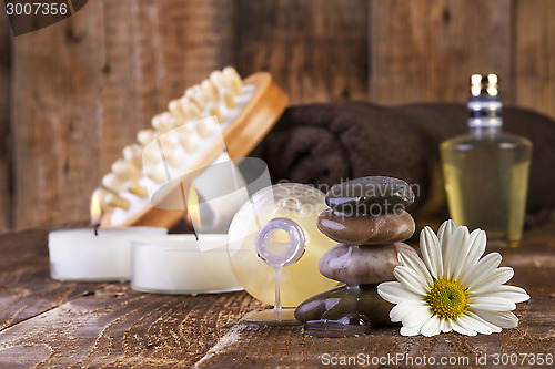 Image of zen basalt stones and spa oil with candles on the wood