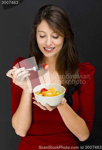 Image of Woman eating a fruit salad