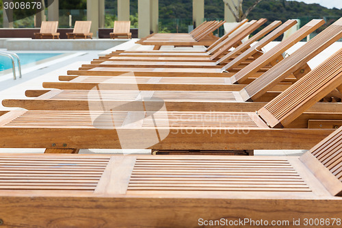 Image of Swimming pool with wooden sunbeds.