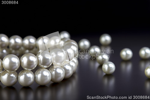 Image of white pearls necklace on black  