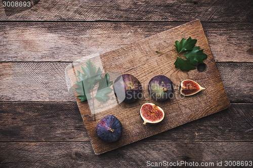 Image of Cut Figs on chopping board and wooden table
