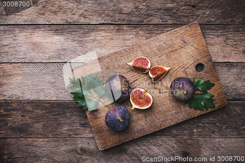 Image of rustic style Cut figs on chopping board and wooden table