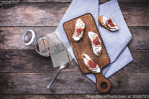 Image of Bruschetta and Sliced figs on chopping board in rustic style