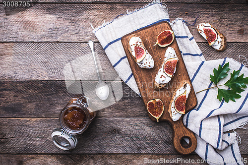 Image of Bruschetta with figs on chopping board in rustic style