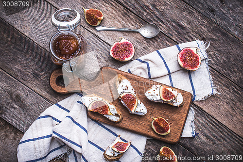 Image of Tasty Bruschetta with jam and figs on napkin in rustic style