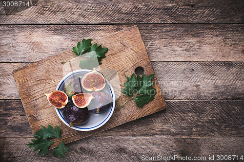 Image of rustic style Cut figs in flat dish on choppingboard