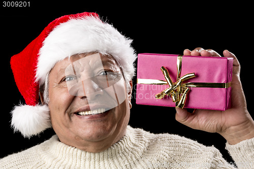 Image of Excited Old Man With Santa Cap And Magenta Gift