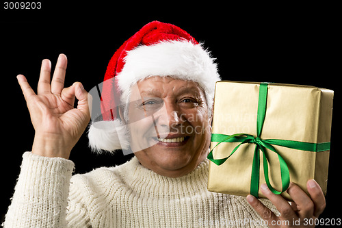 Image of Grinning Male Senior With Gift Gesturing OK Sign