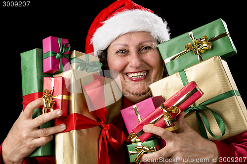 Image of Cheerful Aged Woman Embracing Wrapped Presents 
