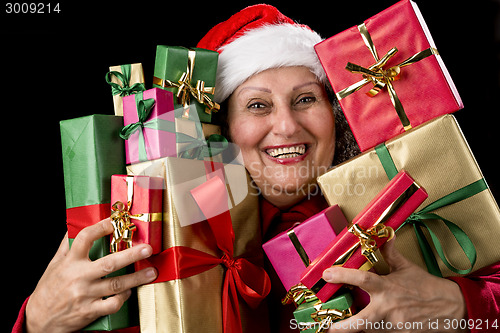 Image of Cheerful Female Senior Embosoming Wrapped Gifts
