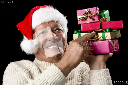 Image of Male Senior Firmly Pointing At Six Wrapped Gifts