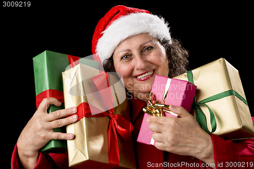 Image of Smiling Aged Woman Embracing Four Wrapped Gifts
