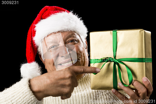 Image of Broadly Grinning Aged Male Pointing At Golden Gift