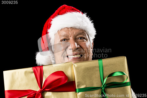 Image of Smiling Aged Man Peeking Across Two Golden Gifts