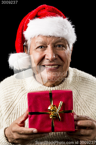 Image of Aged Man With Santa Claus Cap and Red Xmas Gift