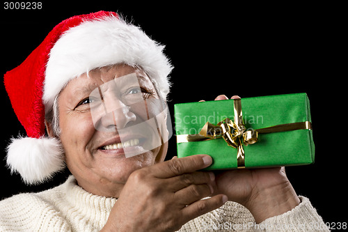 Image of Elderly Man with Santa Cap And Green Wrapped Gift