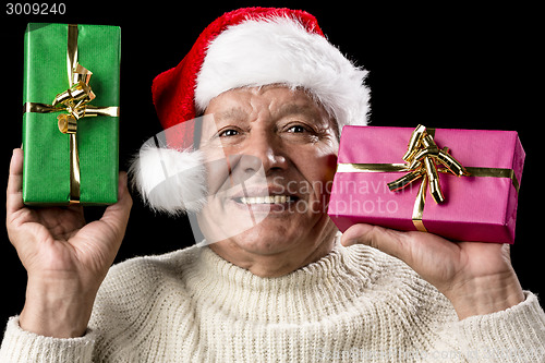 Image of Kind Aged Gentleman With Red Cap Raising Two Gifts