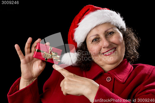 Image of Joyful Aged Lady Pointing at Red Christmas Gift
