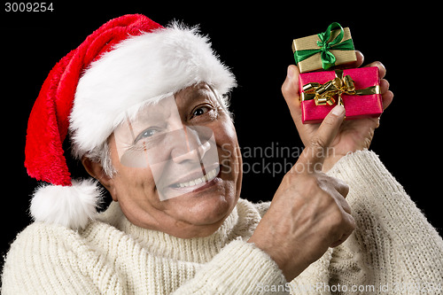 Image of Smiling Senior Pointing At Two Wrapped Xmas Gifts