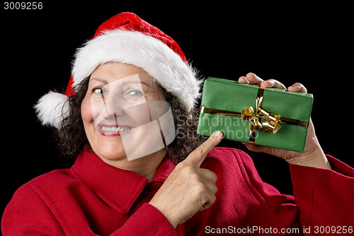 Image of Smiling Mature Woman Pointing at Wrapped Xmas Gift
