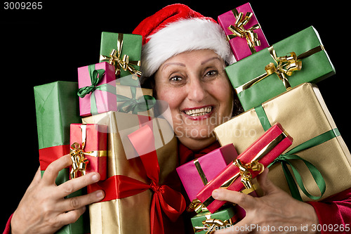 Image of Delighted Old Lady Hugging a Dozen Wrapped Gifts
