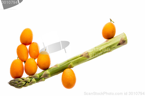 Image of Seesaw Made From One Asparagus and Eight Kumquats