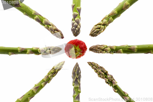Image of Eight Asparagus Spears Pointing at One Strawberry