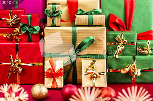 Image of Three Piles of Xmas Gifts in Red, Gold and Green