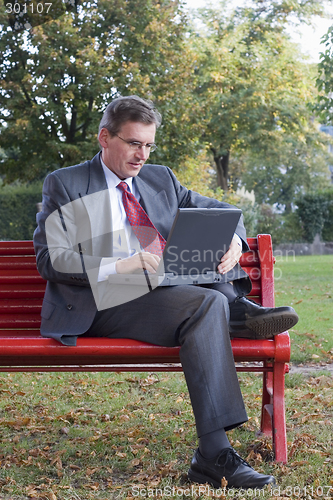 Image of Businessman with laptop outside