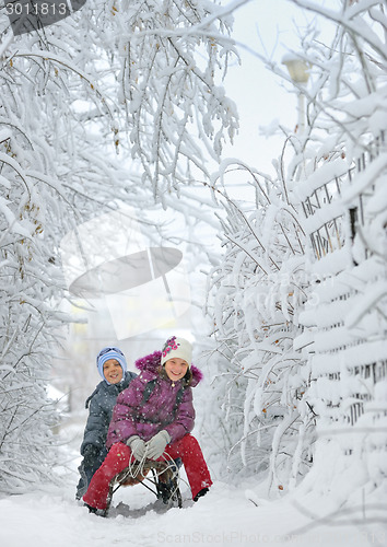 Image of Boy And Girl at sledging Through Snowy