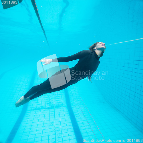 Image of Female diver flying underwater in swimming pool