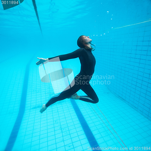 Image of Female diver flying underwater