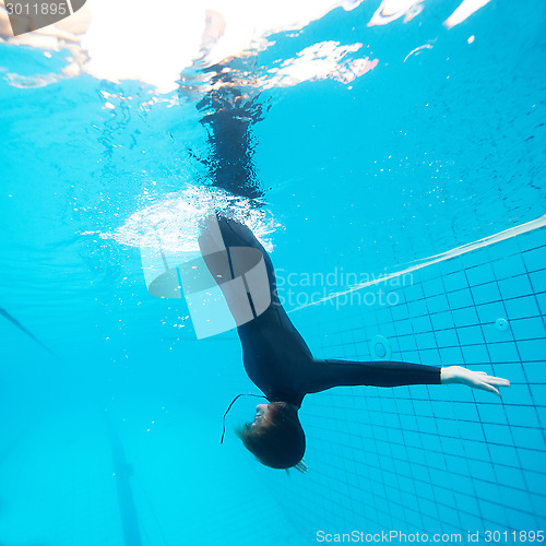 Image of Female diving downwards in swimming pool