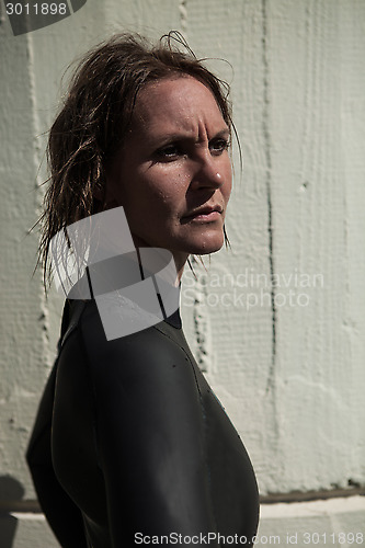 Image of Attractive serious looking female swimmer wearing wetsuit