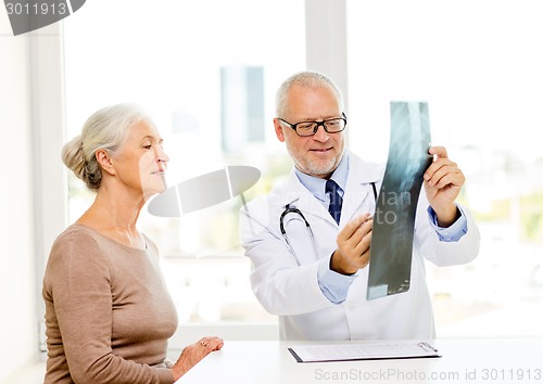 Image of smiling senior woman and doctor meeting