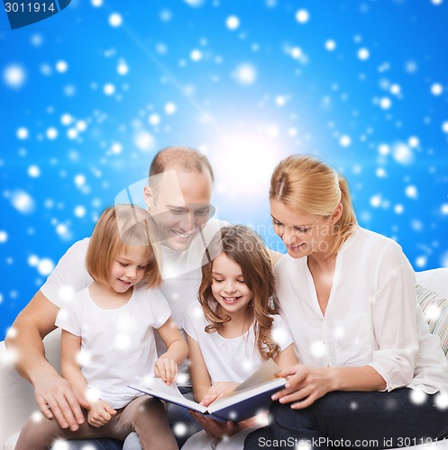 Image of happy family with book at home