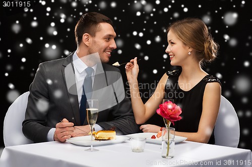 Image of smiling couple eating dessert at restaurant