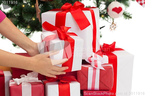 Image of close up of woman with presents and christmas tree