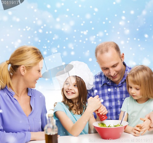 Image of happy family with two kids making salad at home