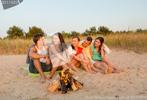 Image of smiling friends in sunglasses on summer beach