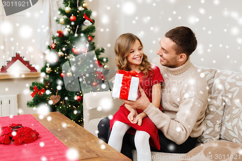 Image of smiling father and daughter holding gift box