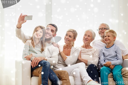 Image of happy family taking selfie with smartphone at home